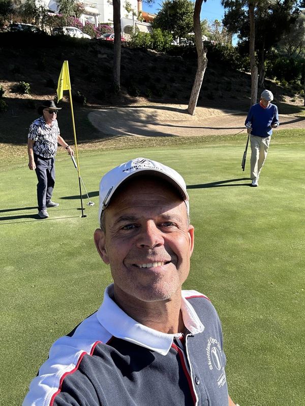 Smilende selfie av Bobby på en solfylt green i Spania