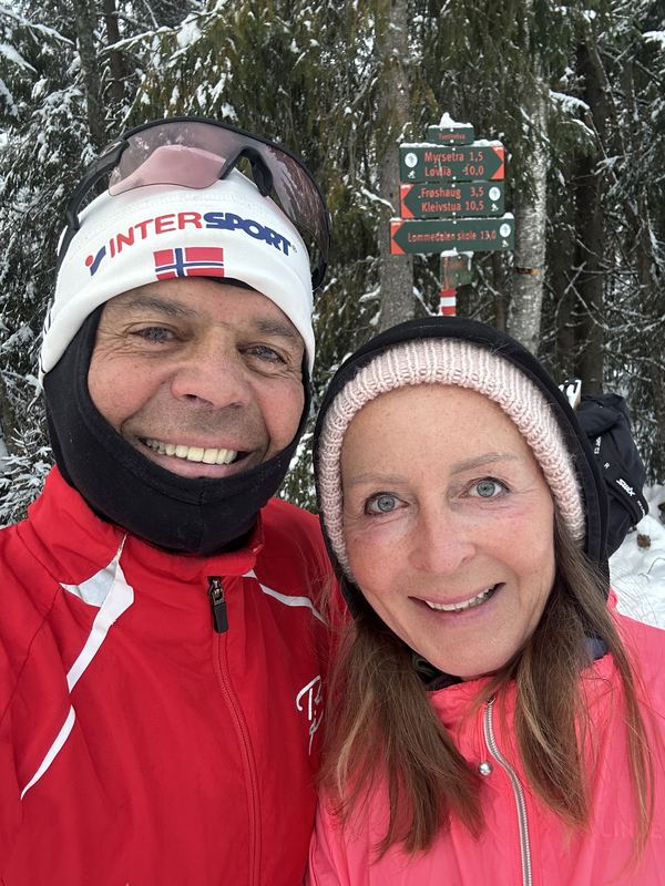 Selfie av Bobby og Siw i skiklær i snødekt skog, med løypeskilt bak seg